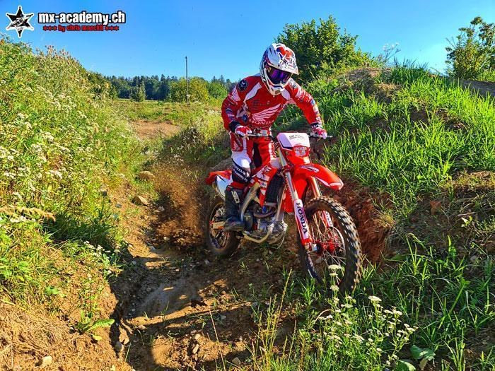 Enduro-Fahrer fährt durch einen Graben im Gelände